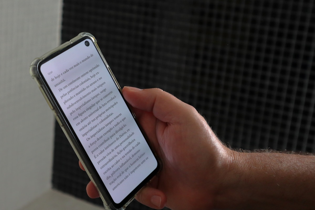 a person holding a smart phone with a book on the screen