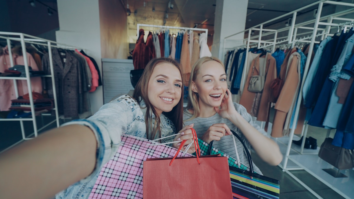 Two happy women take a selfie after shopping.