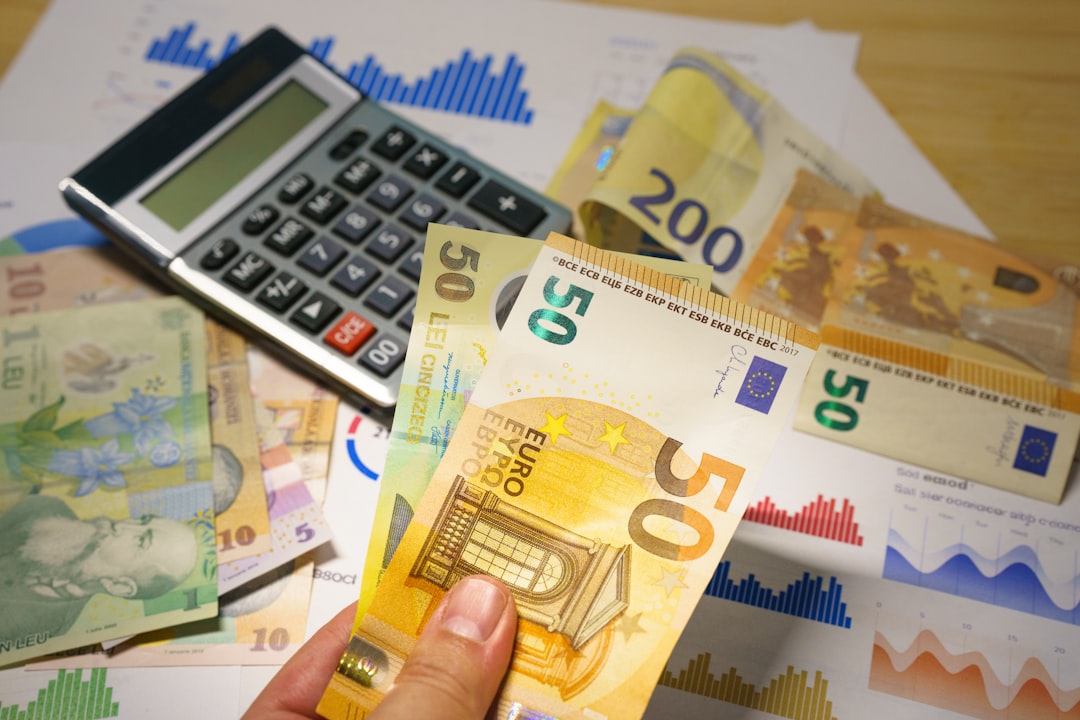 quelle serrure choisir selon budget - A person holding a bunch of money next to a calculator