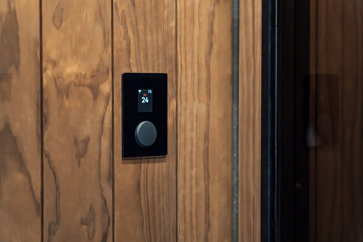 Thermostat numérique sur un mur en bois.