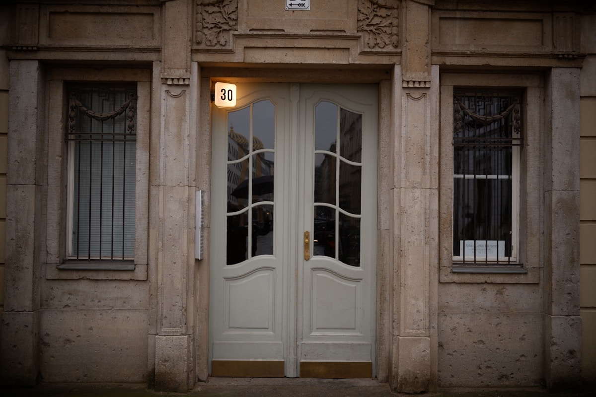 Entrée ornée de style architectural ancien avec numéro 30 éclairé.