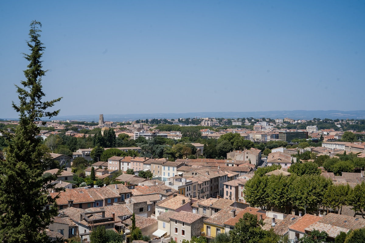 Panorama urbain méditerranéen avec toits de tuiles et clocher.
