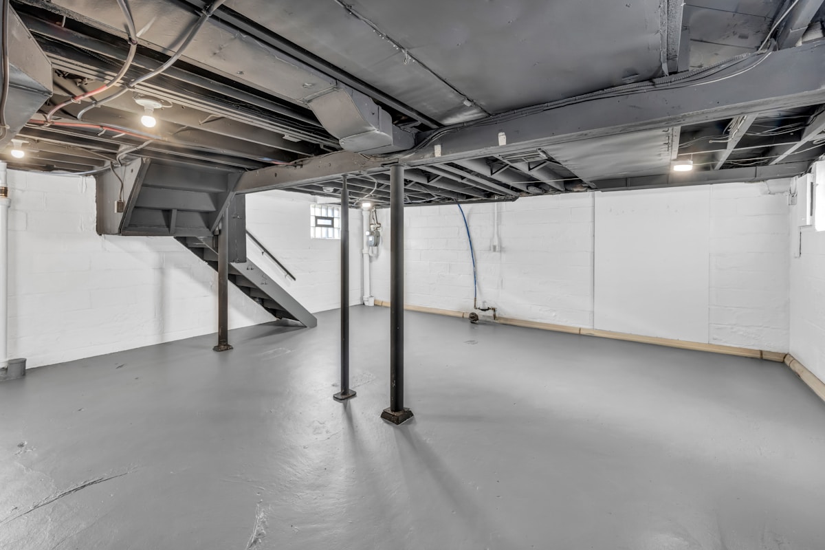 Intérieur d'un sous-sol avec structure métallique et sol en béton.
