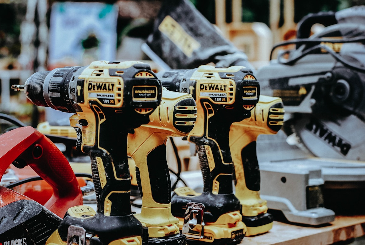 Perceuses-visseuses DeWalt jaunes alignées dans un atelier.
