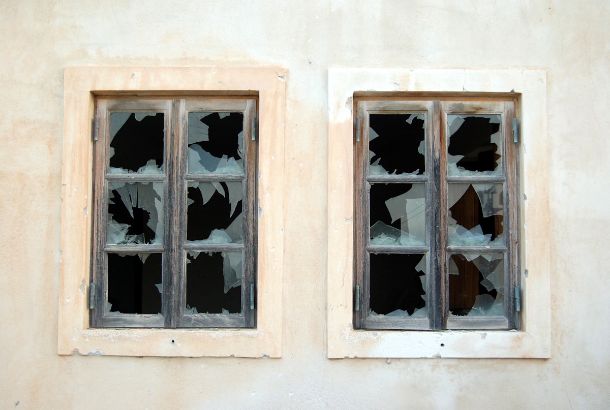 Fenêtres cassées dans un mur en béton délabré.