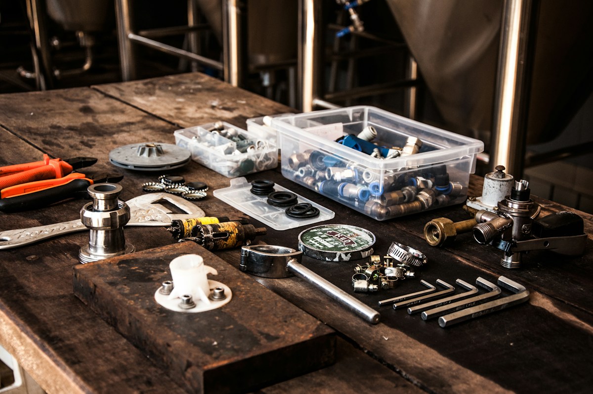 Établi d’atelier avec outils, raccords et pièces métalliques variés