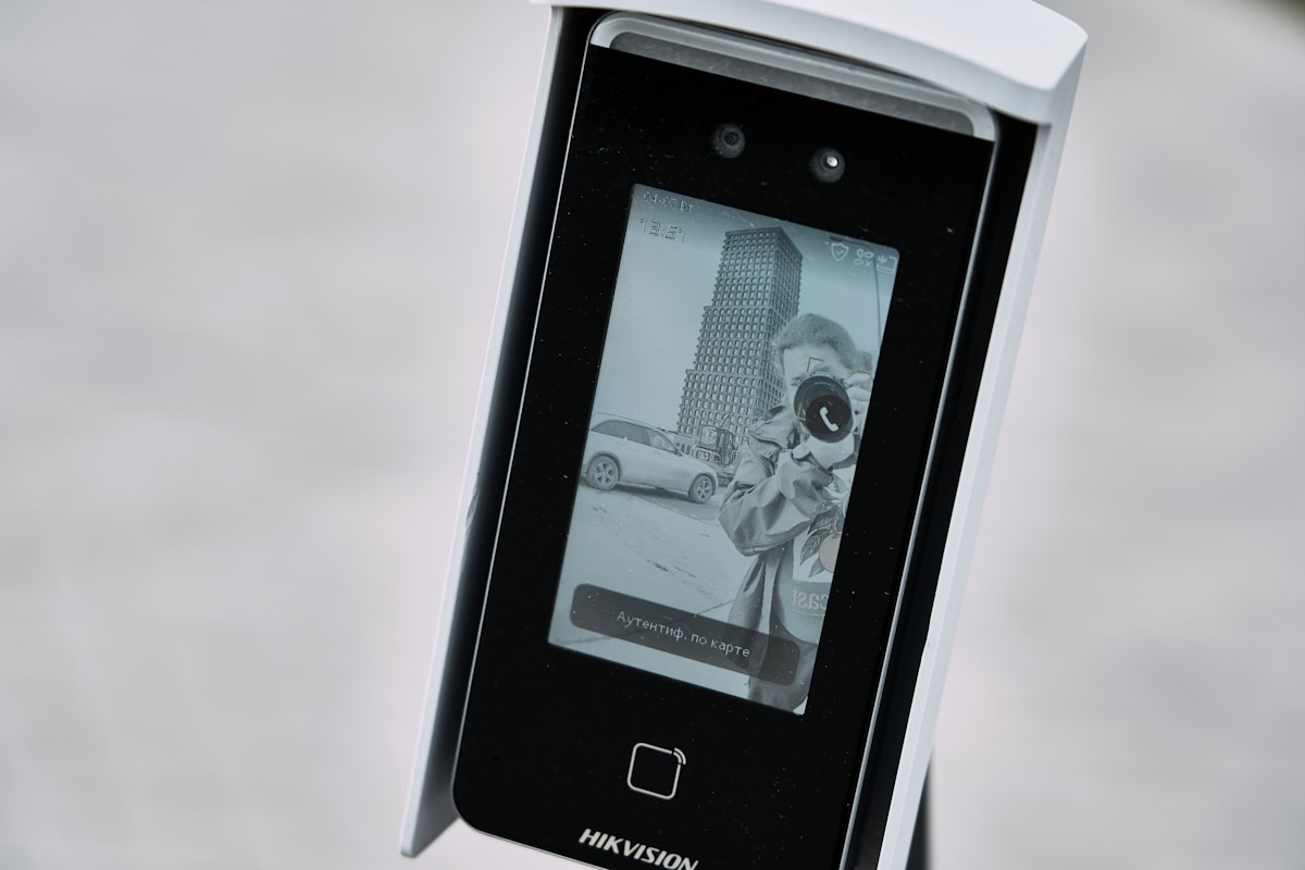 Caméra de surveillance avec écran affichant une scène urbaine en noir et blanc.