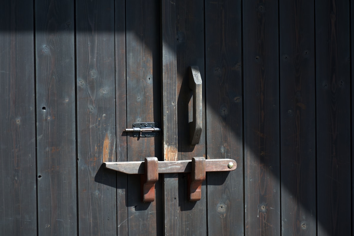 Porte en bois sombre avec verrou en métal.