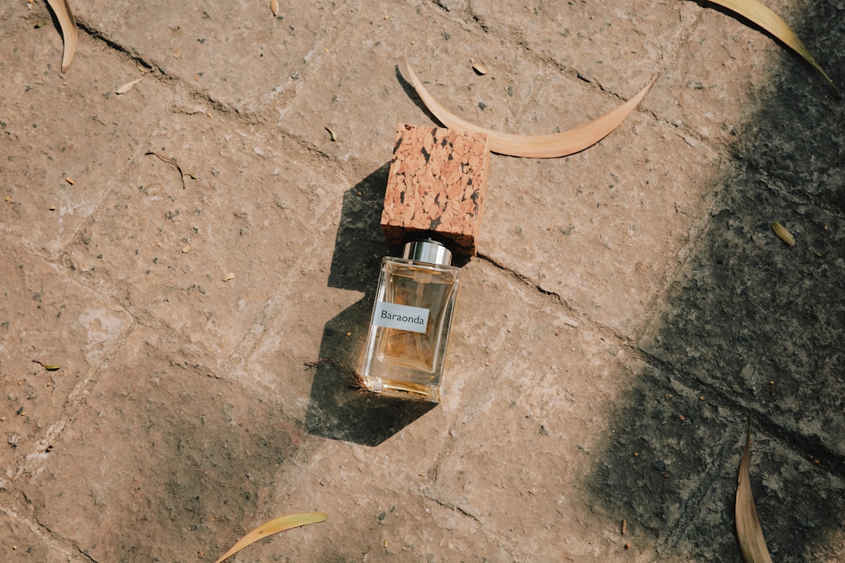 A bottle of perfume with a cork stopper on stone