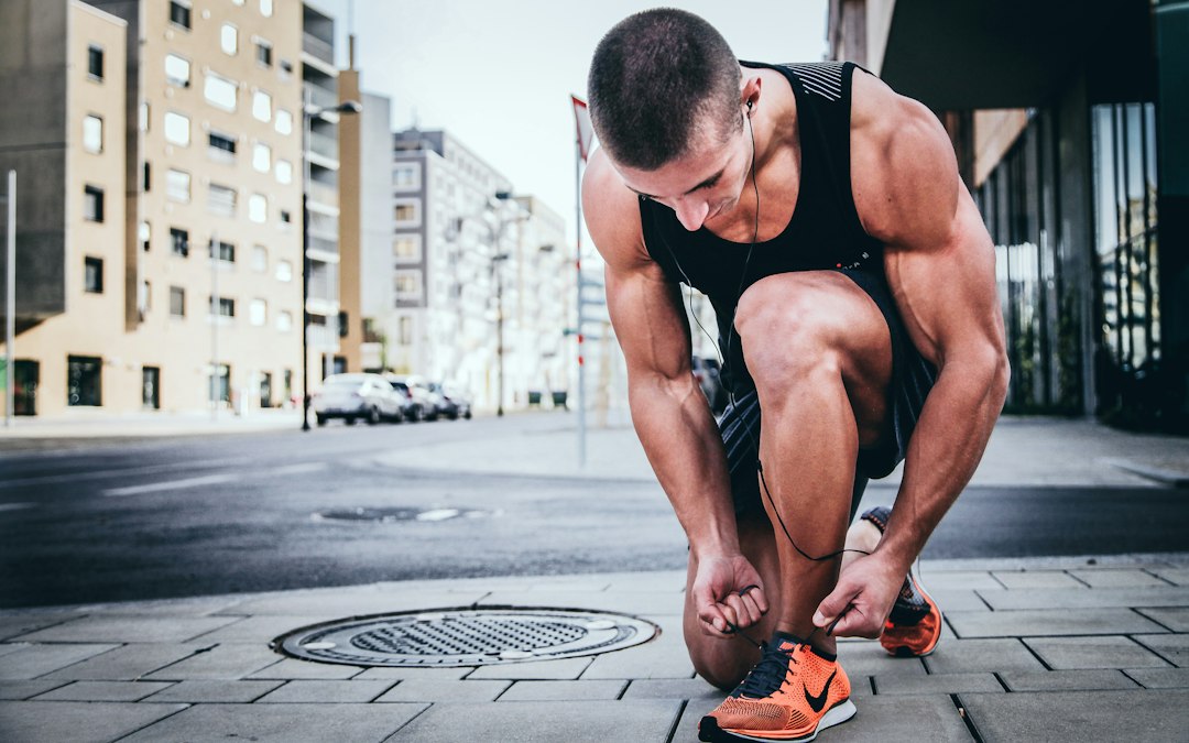 Personne athlétique vérifie son tracker de fitness après entraînement, affichant fréquence et volume entraînement sportif.
