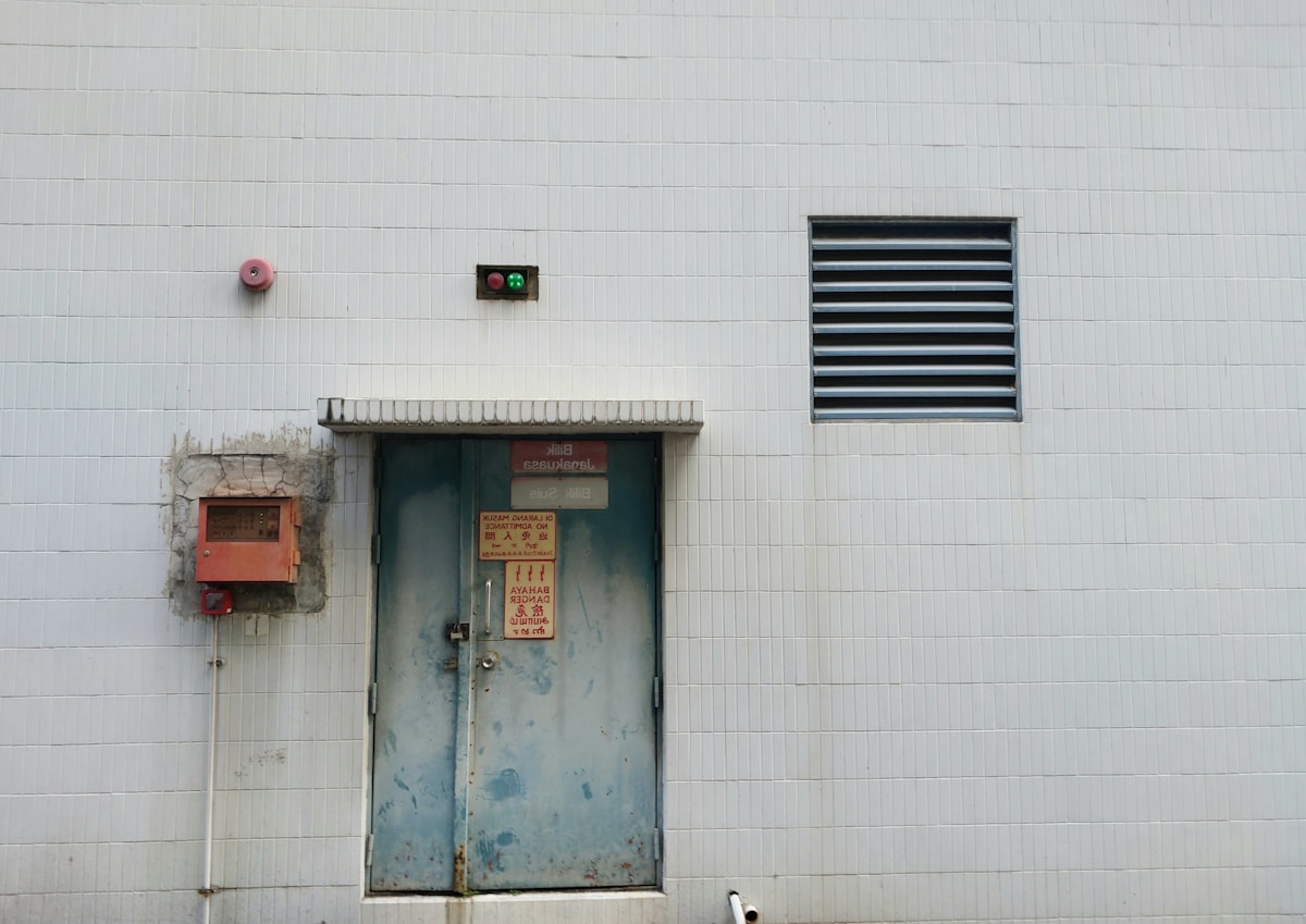 Un chien se tient devant une porte.