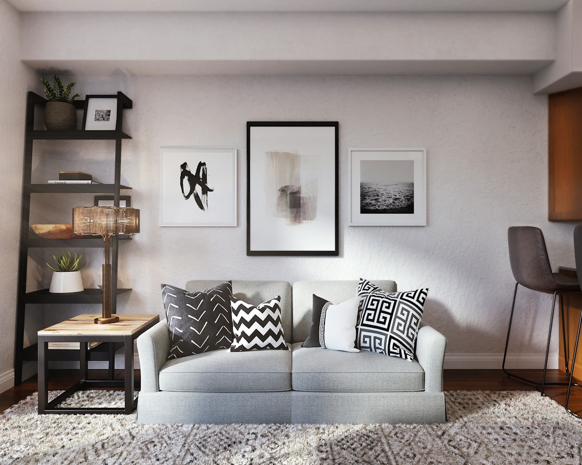 Gemütliches, modern eingerichtetes Wohnzimmer mit Sofa, Regalen und Kunstwerken.