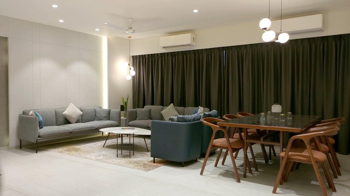 Geräumiges, modern eingerichtetes Wohnzimmer mit Sofa, Tisch und Stühlen.