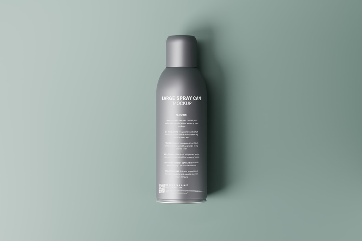 Boîte de spray gris sur fond vert menthe.