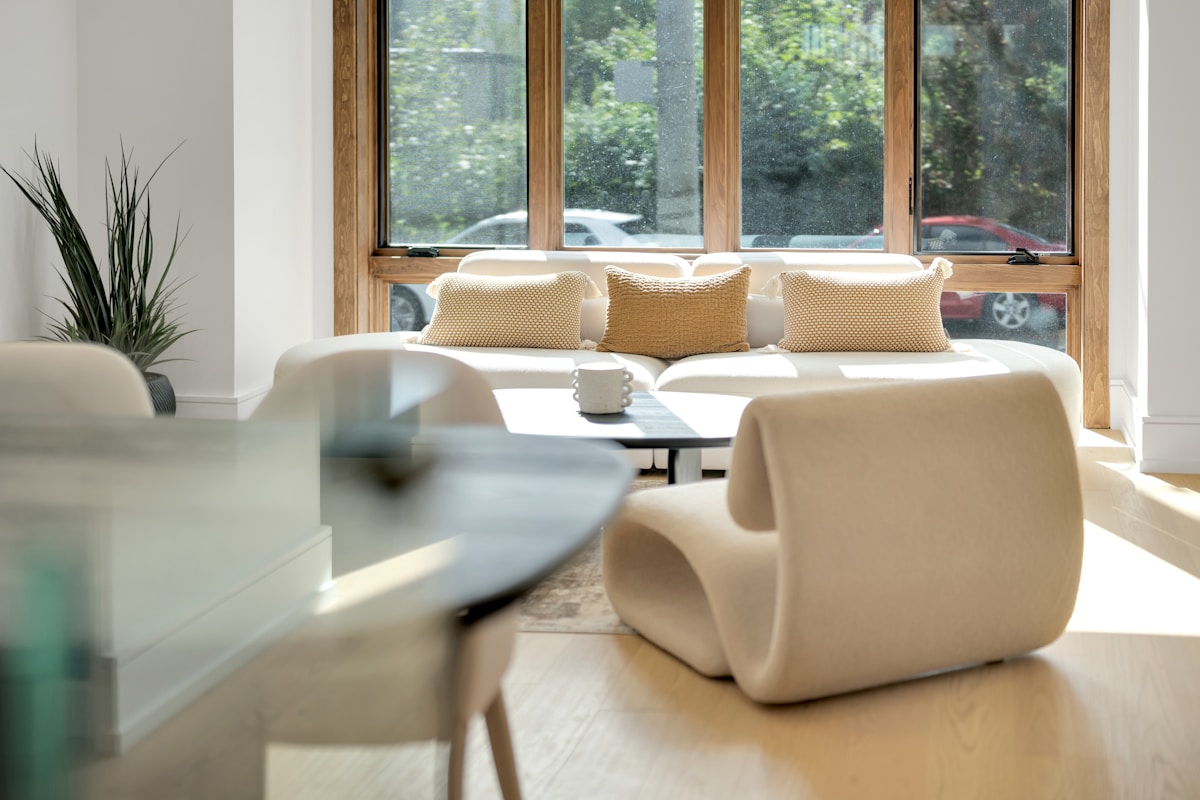Salon lumineux avec canapé confortable et vue sur la nature.