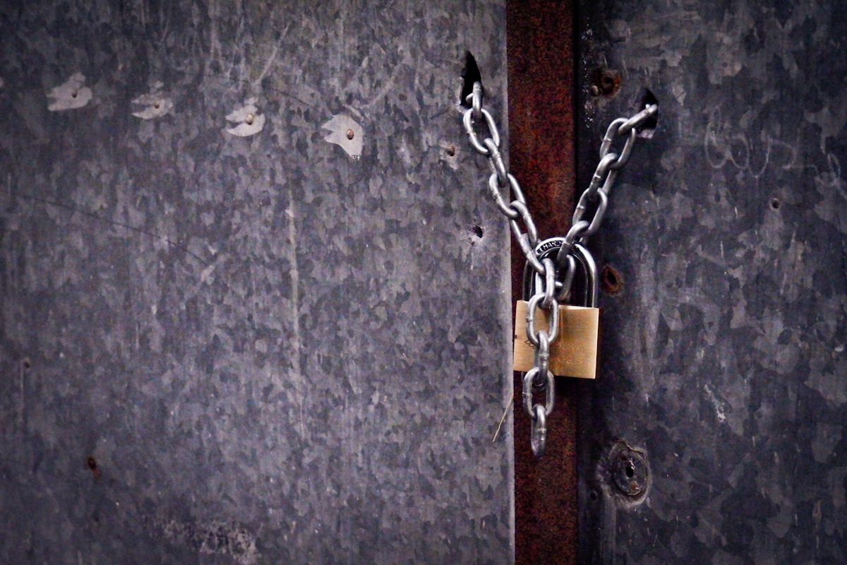 Cadenas rouillé attaché à une porte en métal usée.