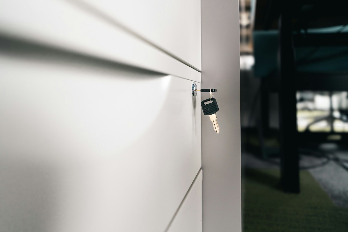 Clé insérée dans serrure d’une armoire blanche moderne
