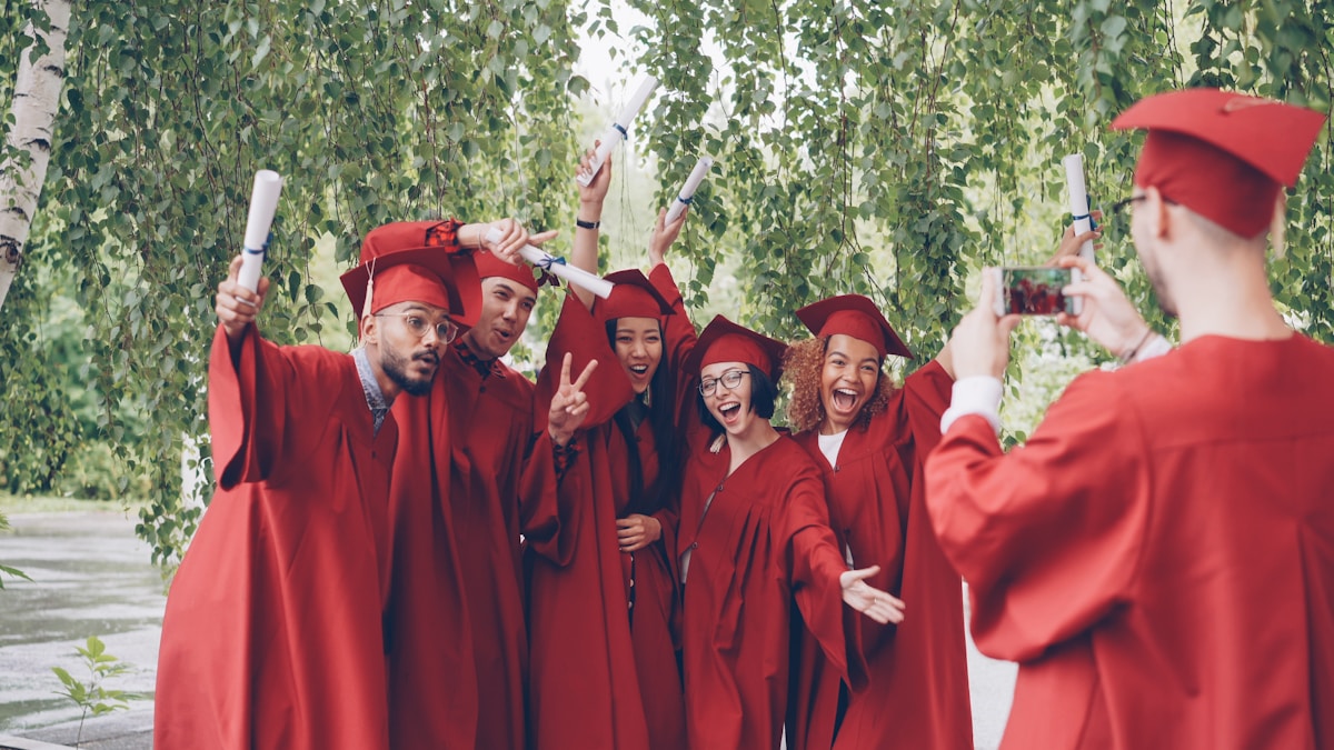 Groupe d'étudiants diplômés en robe rouge célébrant leur réussite.