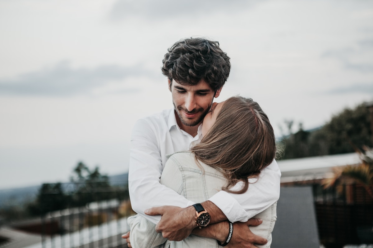 Couple enlacé dans un paysage naturel, expression affectueuse.