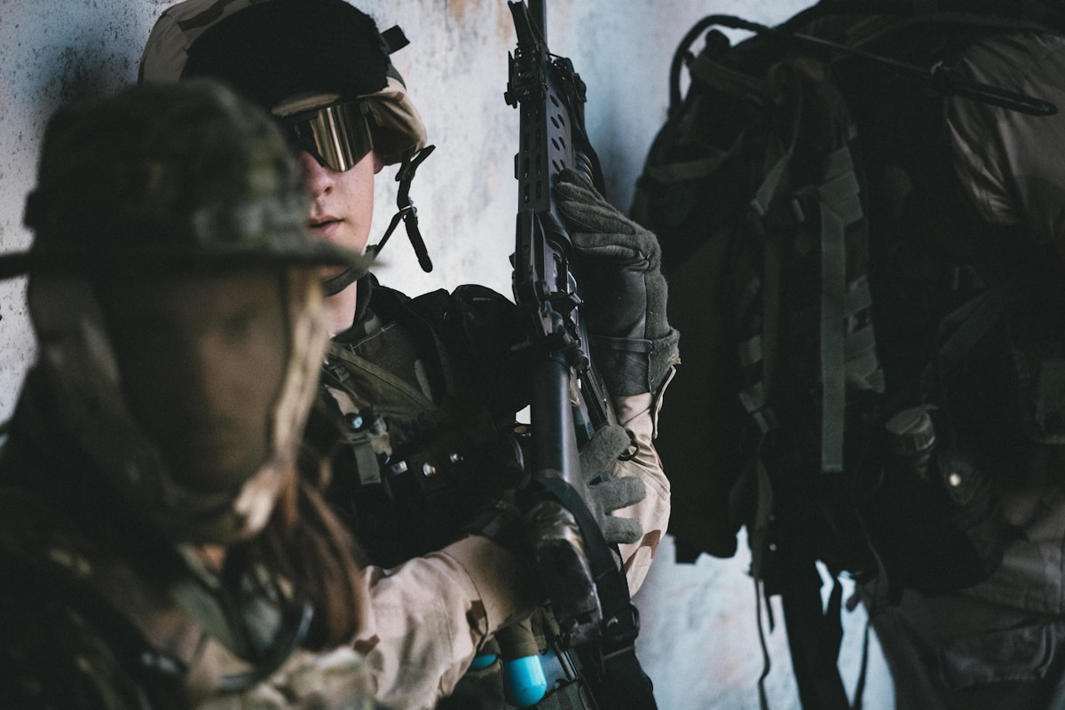 Soldat en tenue de camouflage, armé et prêt au combat.