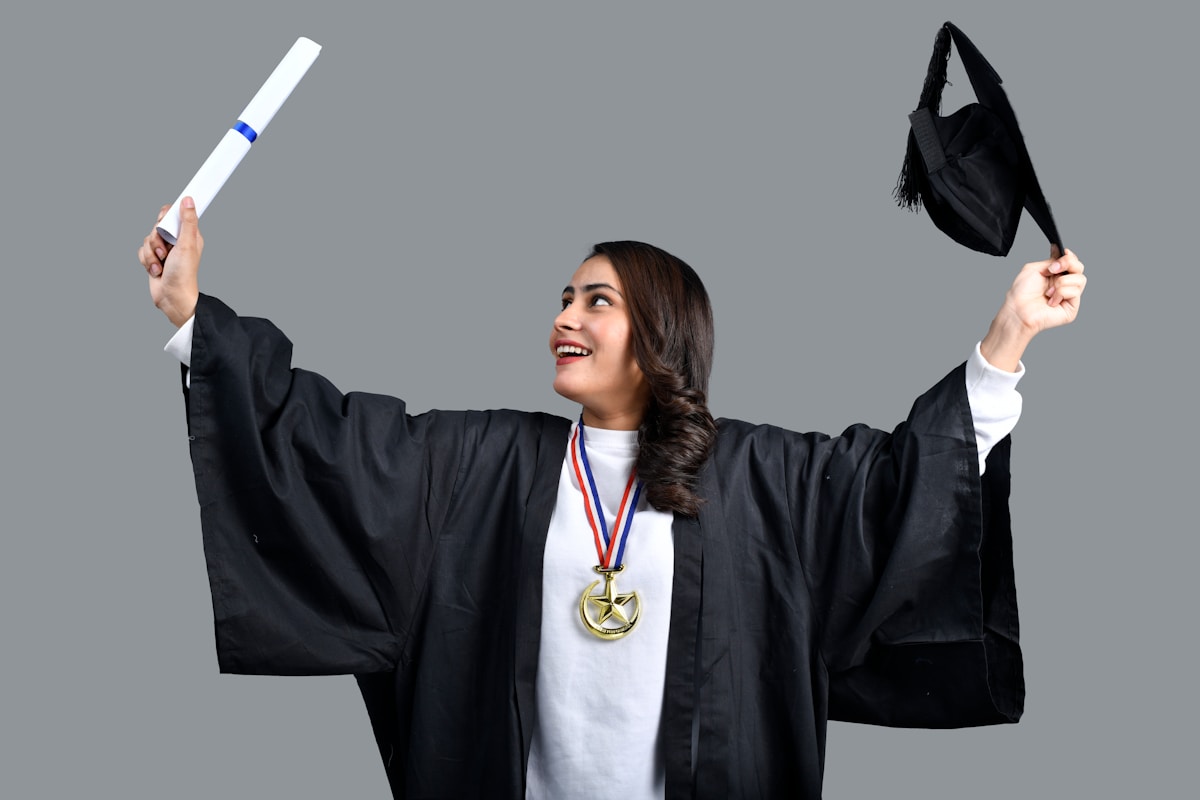 Femme diplômée en robe de graduation, médaille d'or, célébrant son succès.