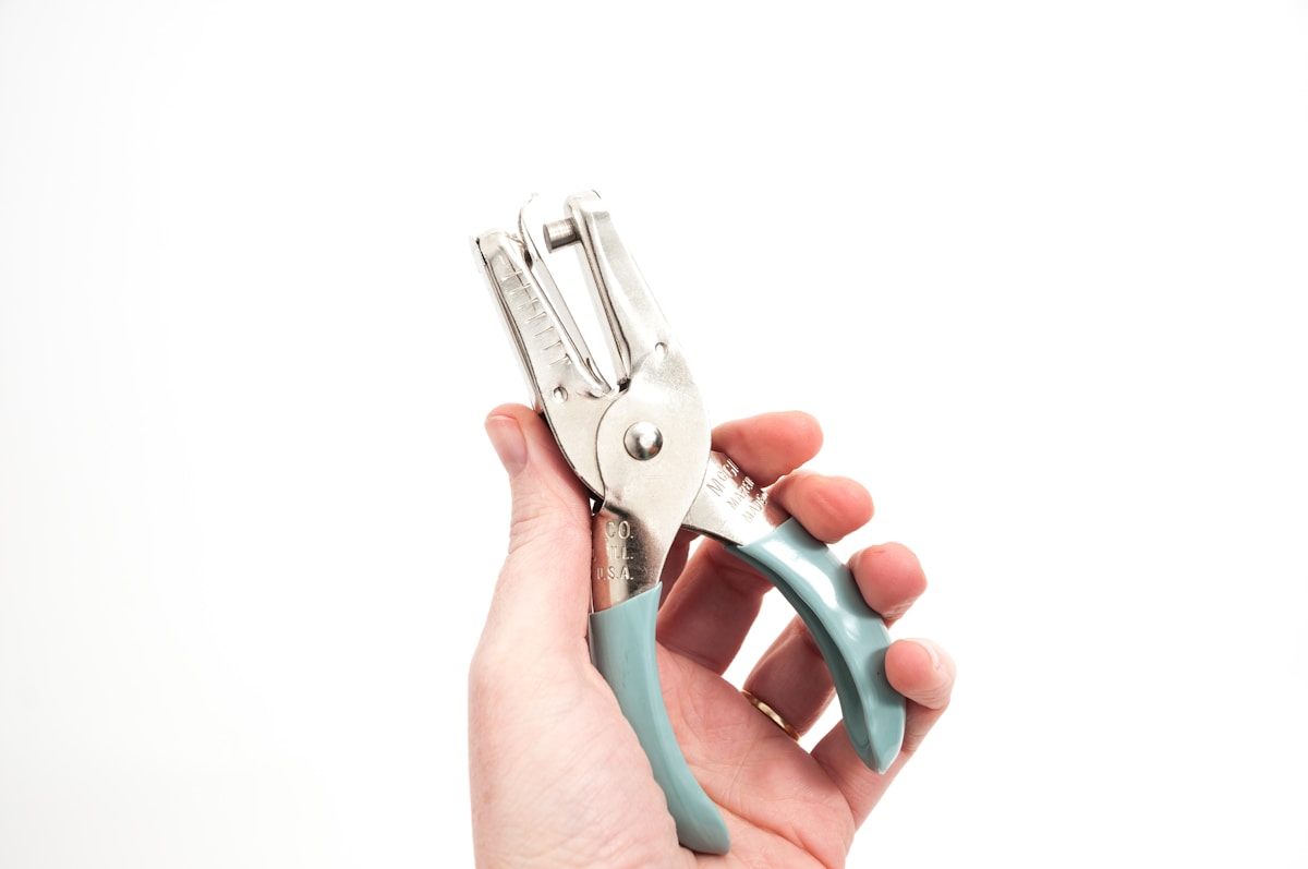 Pince multifonctionnelle en métal avec poignée bleue.