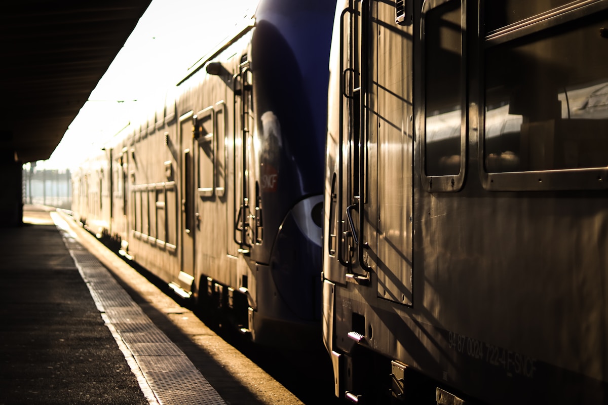 Wagons de train alignés sur une voie ferrée sombre.