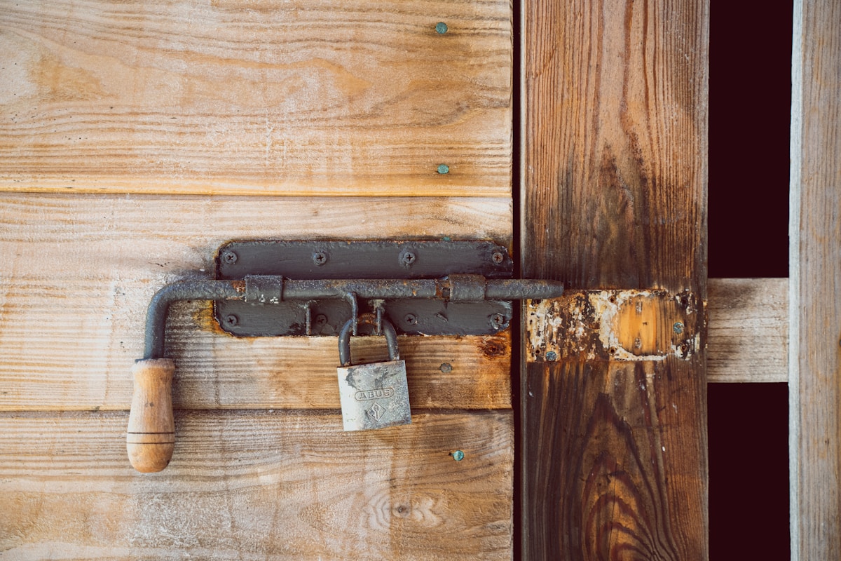 Vieux verrou rouillé sur une porte en bois rustique.