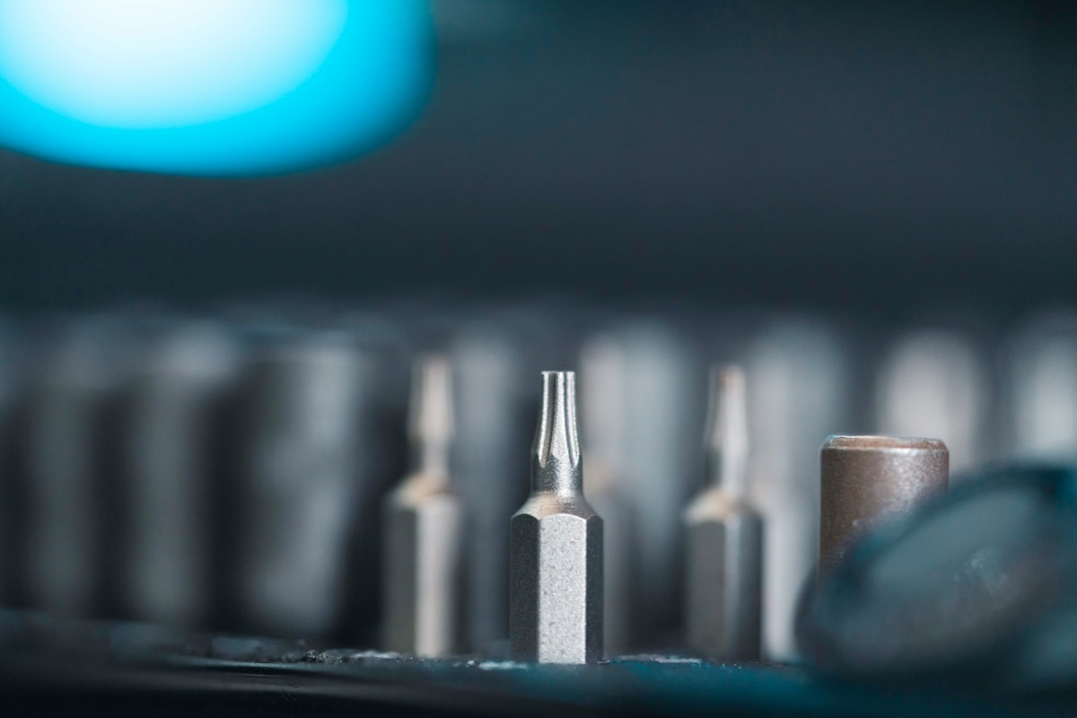 Outils de travail métalliques sur fond sombre et bleu.