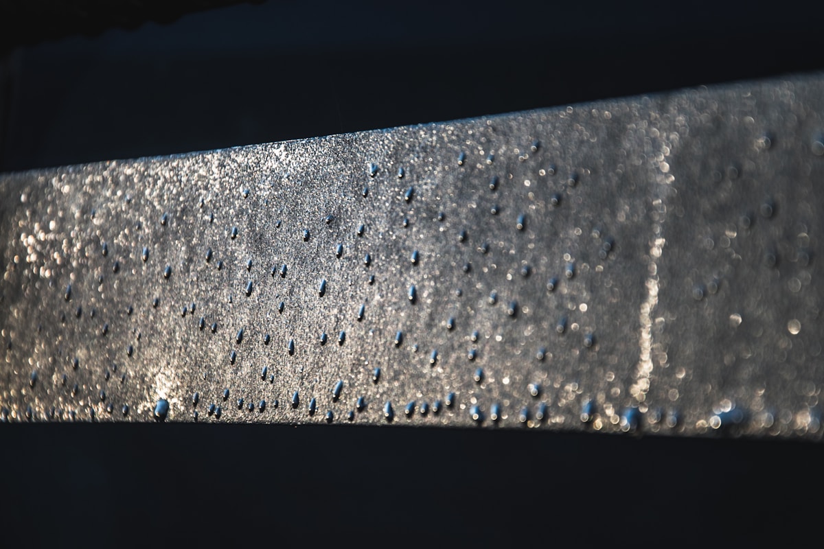 Une surface métallique avec des gouttes d'eau.