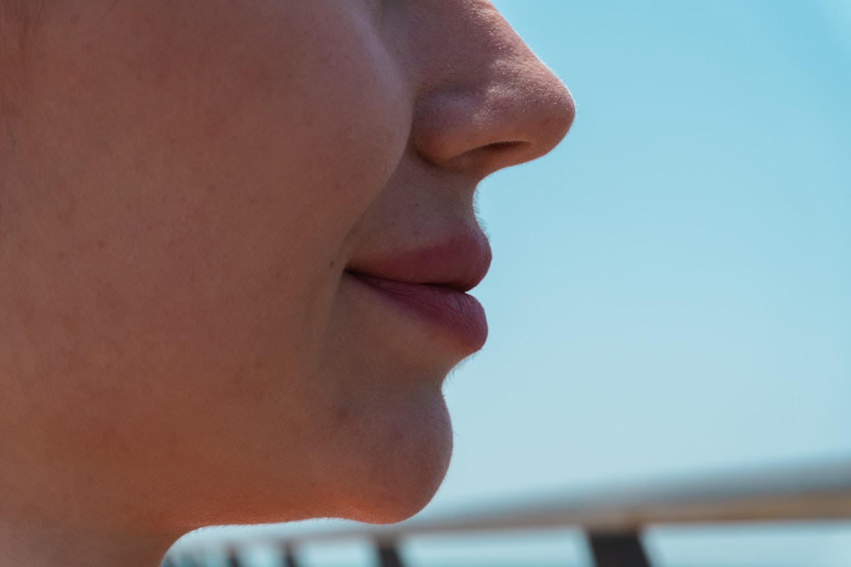 Gros plan du profil du menton et de la bouche d'une femme.