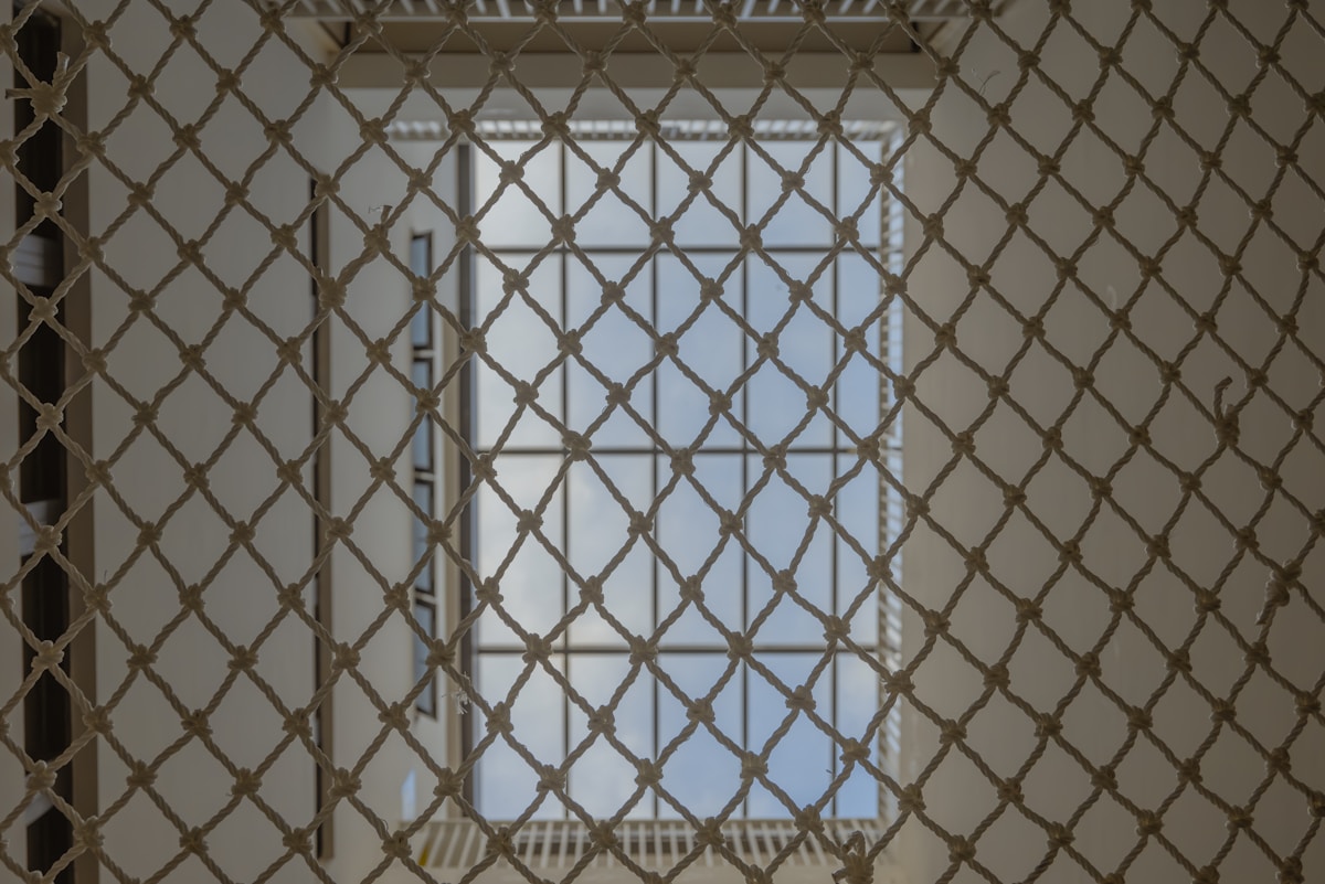 Grille métallique complexe avec motif de diamants.