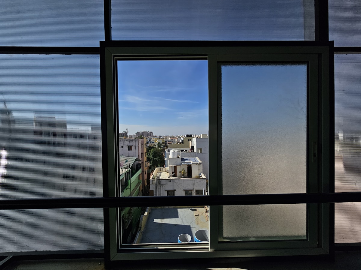 Vue sur les toits de la ville à travers une fenêtre.