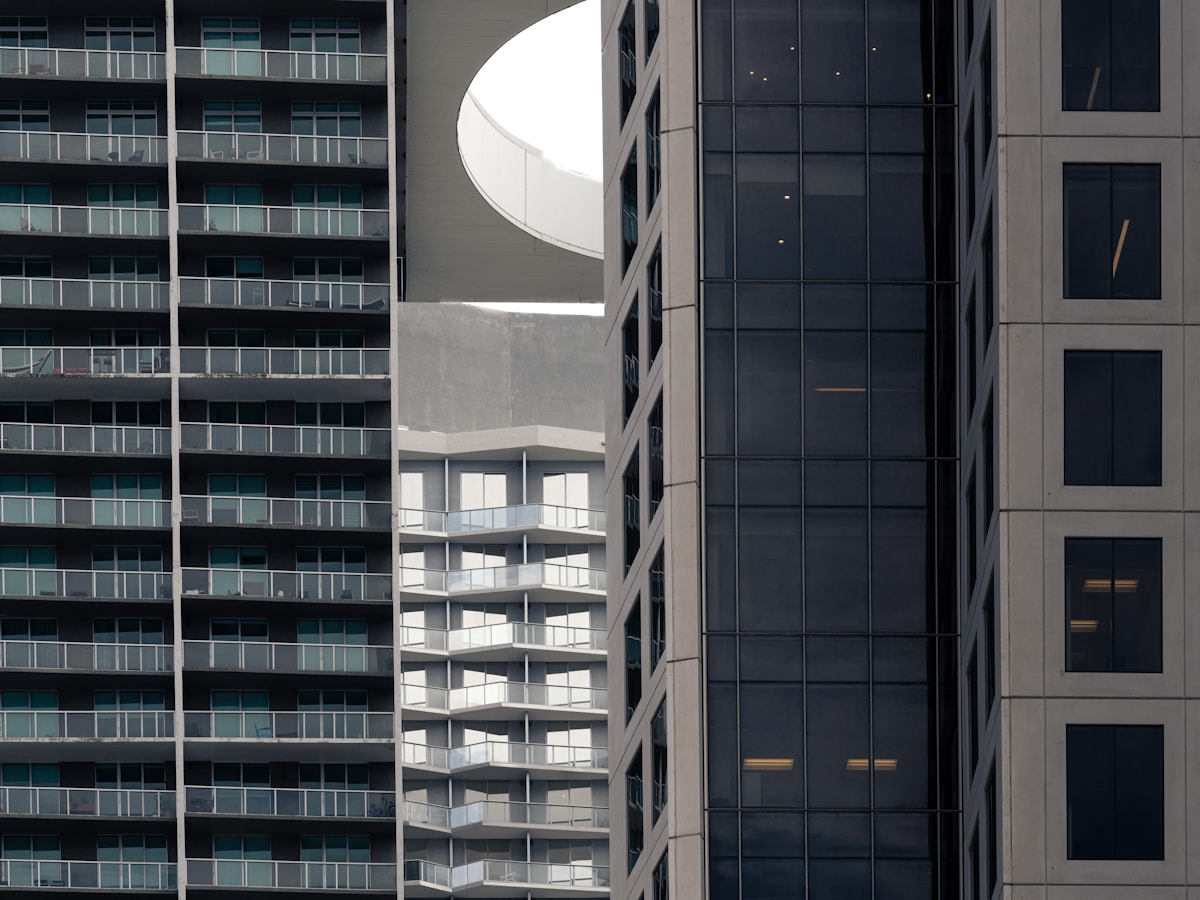 Bâtiments modernes avec fenêtres en verre, formes géométriques, architecture contemporaine.