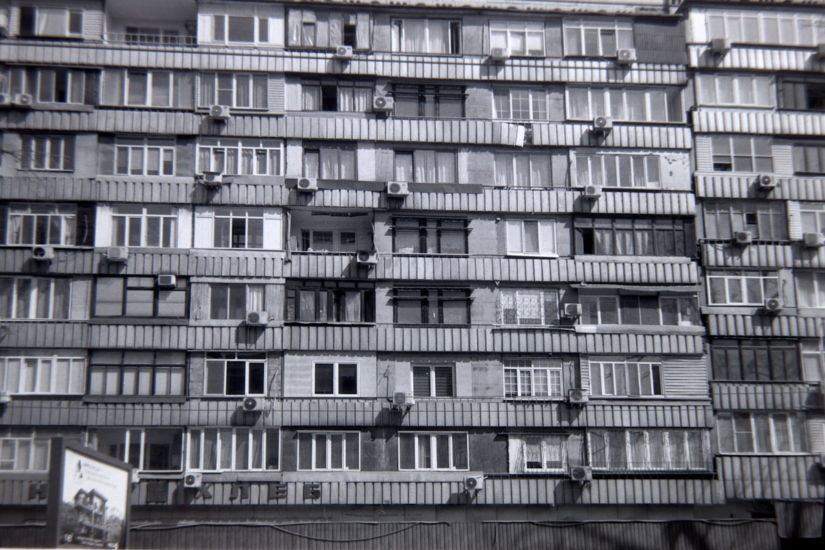 Immeuble soviétique en béton avec de nombreux balcons et fenêtres.