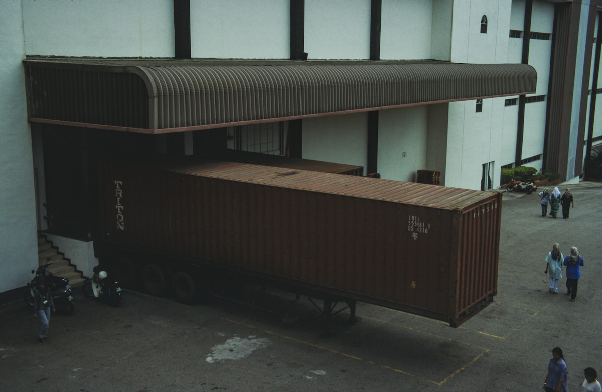 Conteneur de transport maritime marron avec toit ondulé.