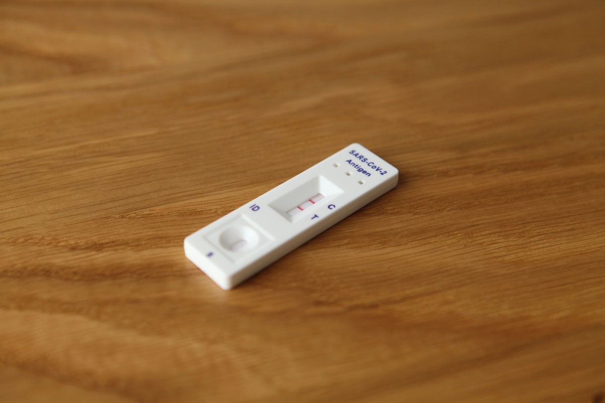 Bandelette de test de grossesse sur une surface en bois.