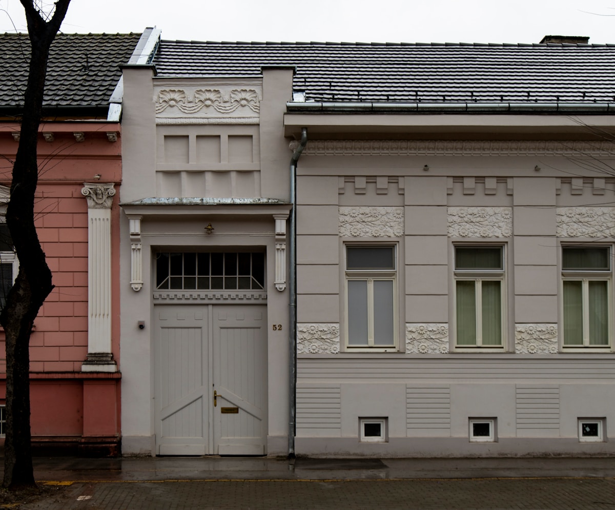 Bâtiment ancien avec façade ornementée et porte blanche.