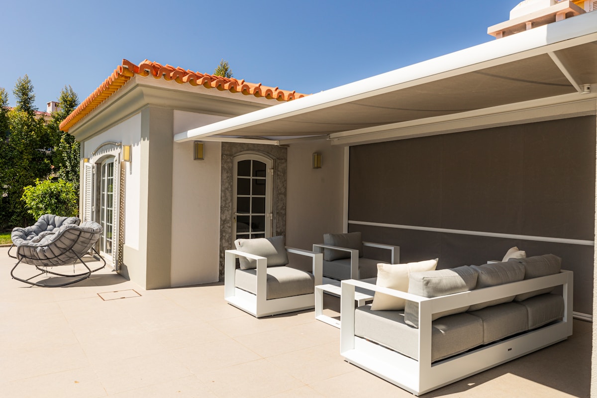 Terrasse extérieure avec mobilier de jardin moderne et toit en tuiles.