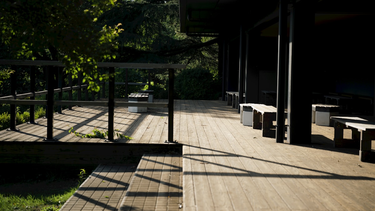 Terrasse en bois avec mobilier dans un environnement boisé.