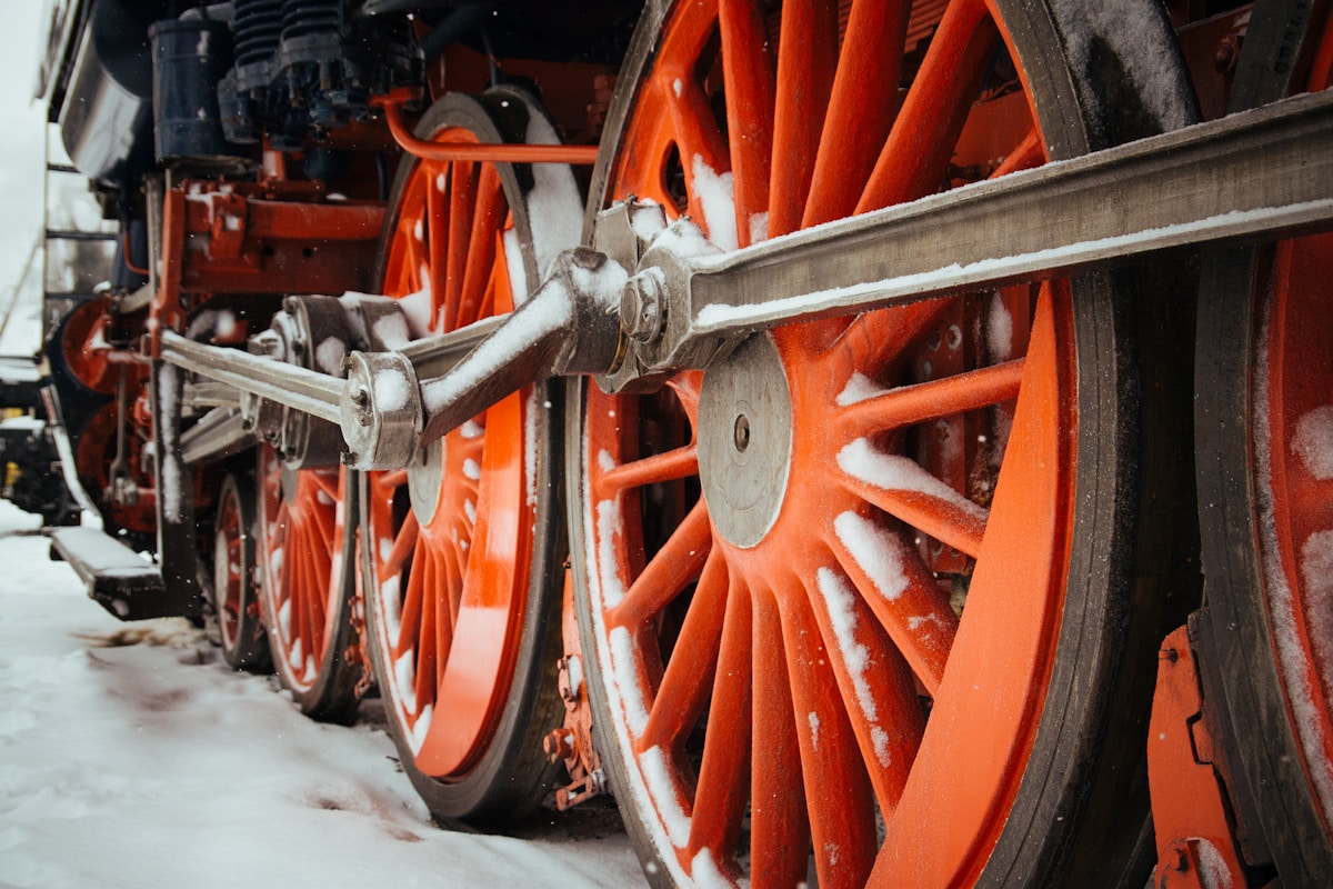 Roues de locomotive à vapeur rouges et détails mécaniques.