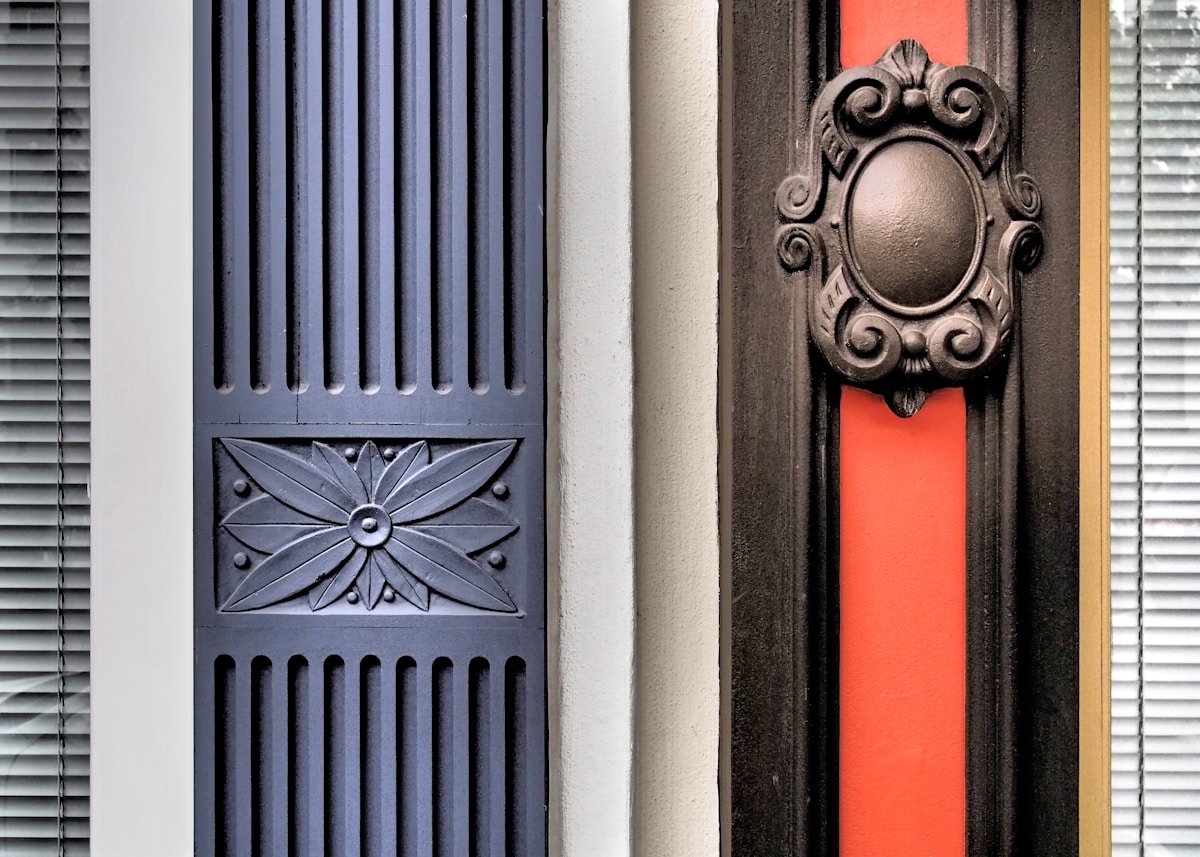 Porte ornementée avec motifs décoratifs et cadre rouge vif.