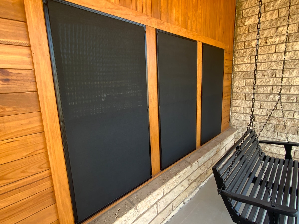 Un banc noir assis près d'un mur de briques.