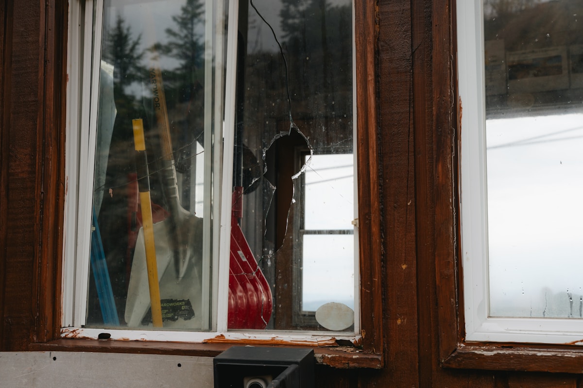 Fenêtre cassée avec des outils et des objets à l'intérieur.