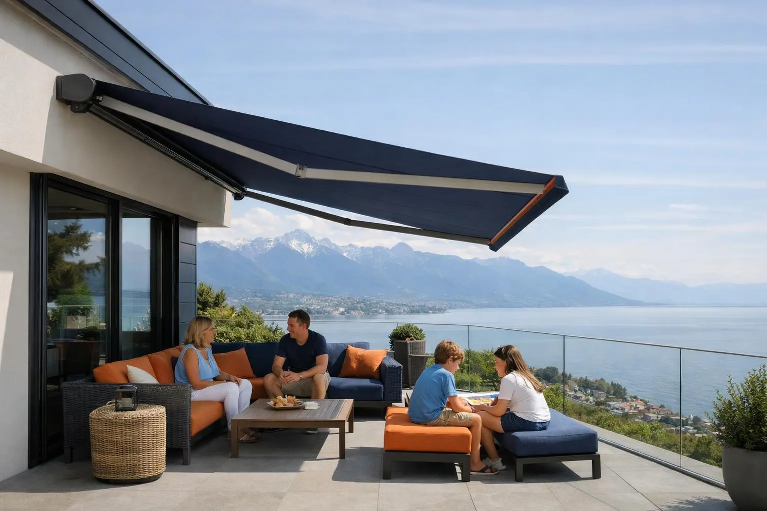 Modern Swiss home terrace with retractable projection awning extended over outdoor seating area, creating shade on sunny summer day, view of Lake Geneva in background, family relaxing underneath, contemporary architecture typical of Vaud canton, warm natural lighting, realistic photographic style