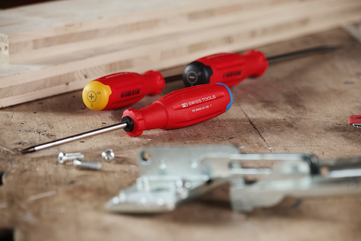 Tournevis rouges posés sur une surface de travail.
