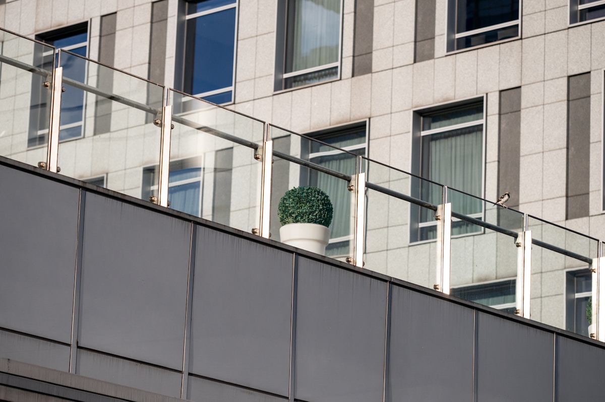 Façade de bâtiment moderne avec balcon vitré.