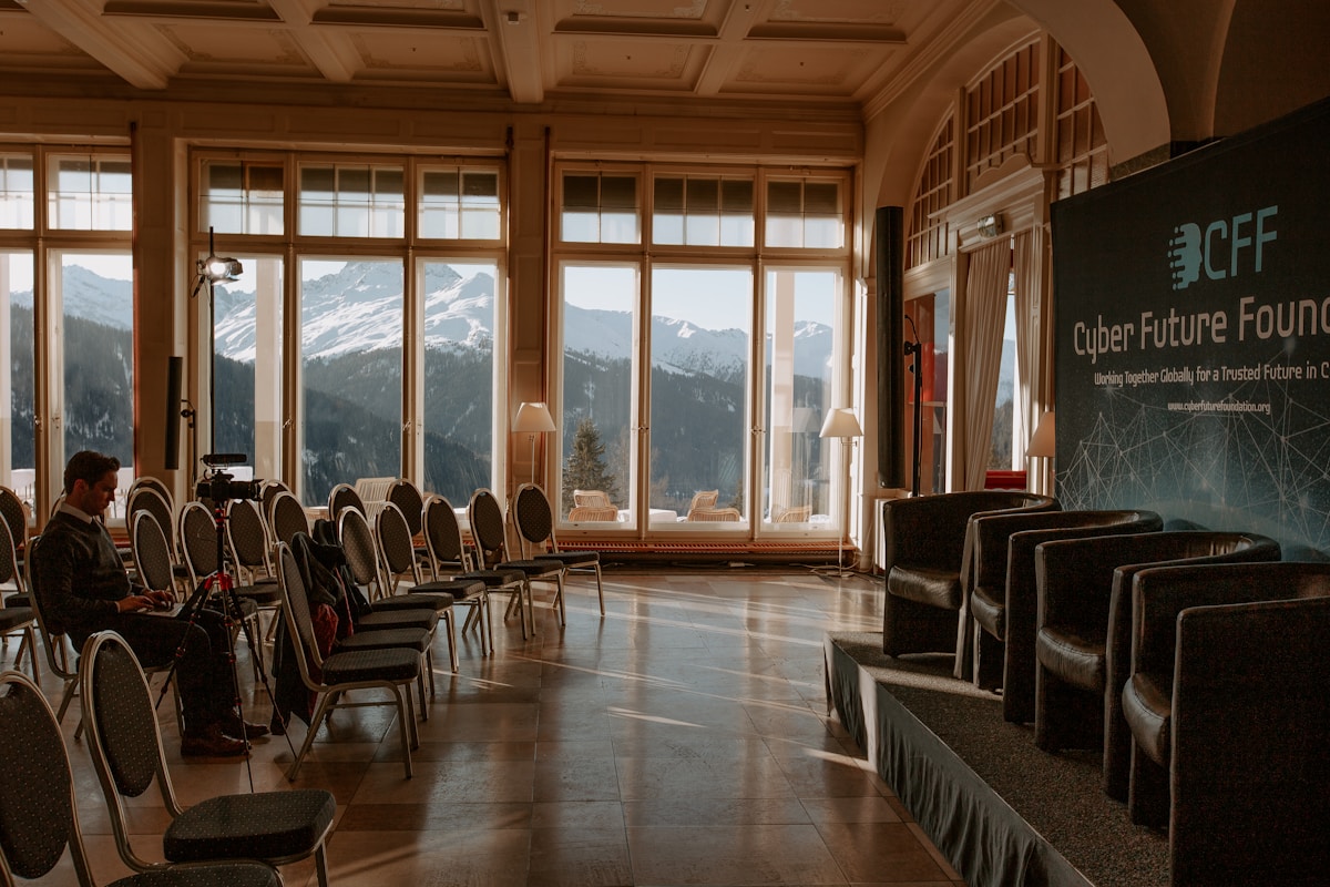 Salle de conférence avec vue panoramique sur les montagnes enneigées.
