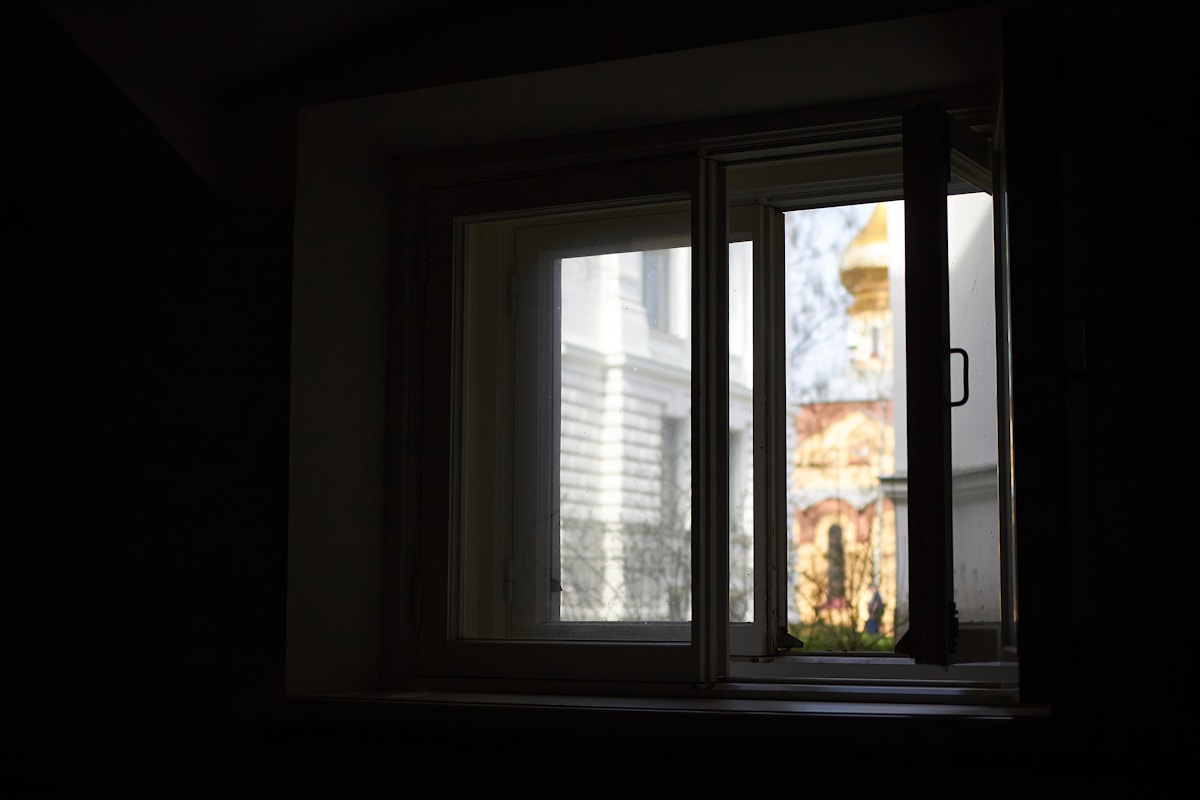 La lumière traverse une fenêtre et inonde une pièce sombre.
