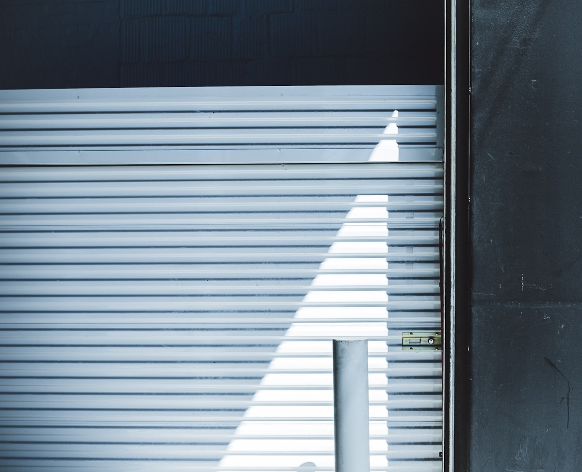 Lignes horizontales métalliques avec une ombre blanche en forme de triangle.